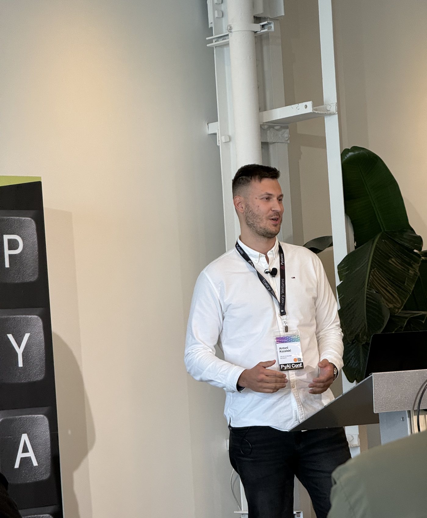 Antoni Kozelski speaking at a lectern at PyAI Conf 2026
