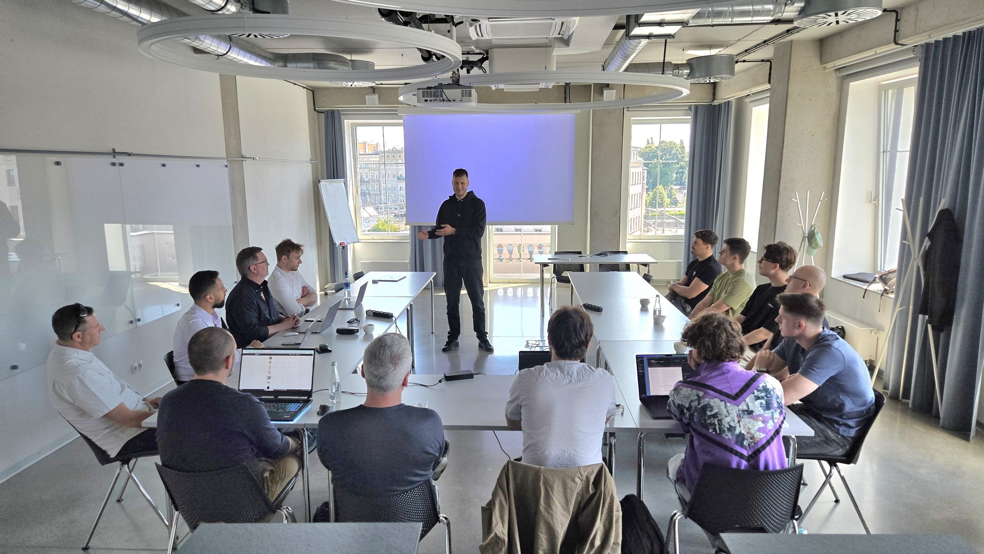 Vstorm scoping workshop in the Warsaw office: the team around U-shaped tables, presenter at the front of the room.